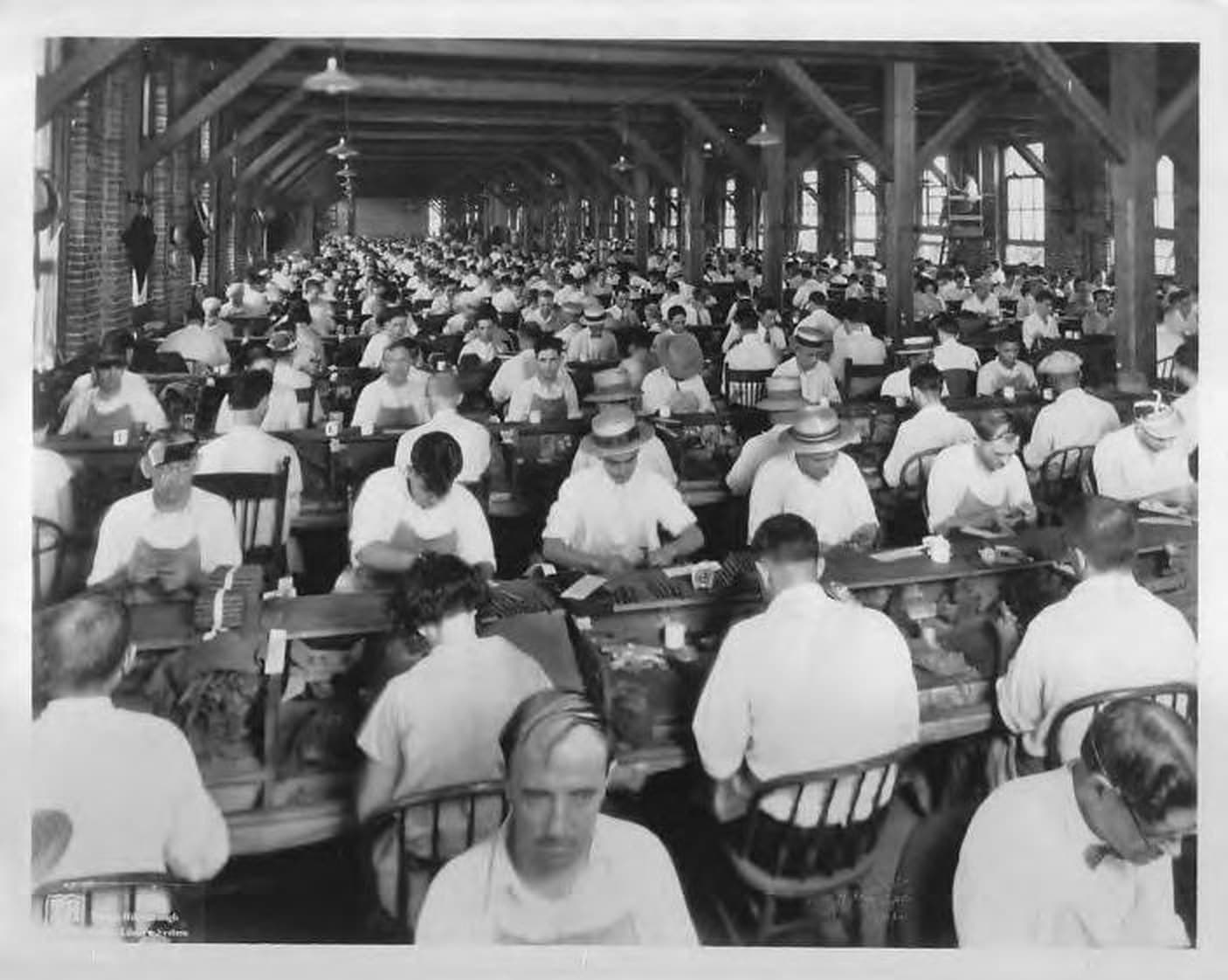 A factory floor in Ybor City in 1929, with the lector on his platform at the back of the room